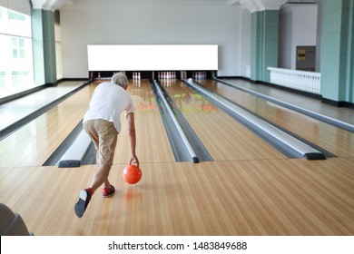 Rear View Older Caucasian Men, White Beard And White Hair In White And Blue Shirt Playing Bowling In Sport Club