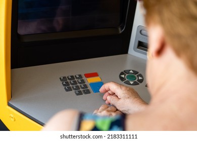 Rear View, Older Woman Entering Personal Data At The ATM.