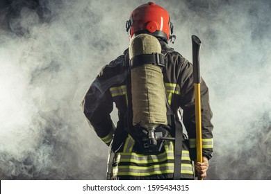 rear view on reverent, confident man working in fire station ready to save people from fire in emergency situations, wearing uniform and helmet