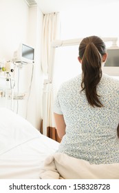 Rear view of patient sitting on hospital bed
