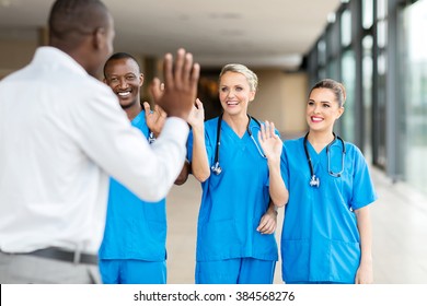 Rear View Of Patient Waving Goodbye To Friendly Medical Team