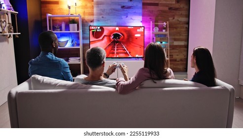 Rear View Of An People Playing Video Games At Home - Powered by Shutterstock