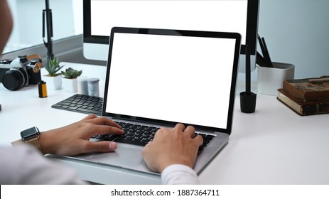 Rear View Of Photographer Or Graphic Designer Working With  Multiple Devices. Blank Screen For Graphics Display Montage. 