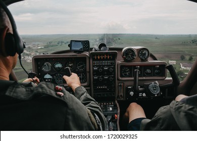 Rear View Of Pilot And Copilot Operating Controls Of Private Plane. Pilot In Cockpit. Aircraft Pilot At Work.