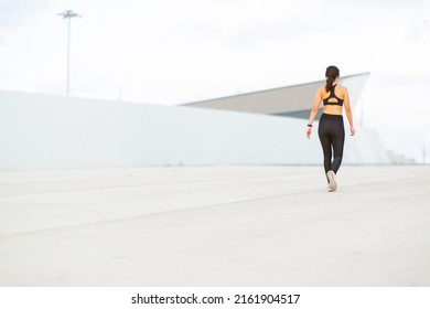 Rear View Portrait Of Active Young Woman Walking Outside In The Morning