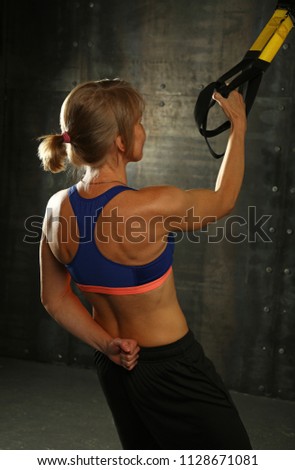 Similar – Rear view portrait of one young middle age athletic woman at crossfit training, exercising with trx suspension fitness straps over dark background