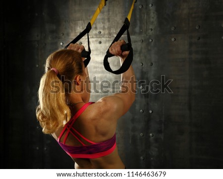 Image, Stock Photo Rear view portrait of one young middle age athletic woman at crossfit training, exercising with trx suspension fitness straps over dark background