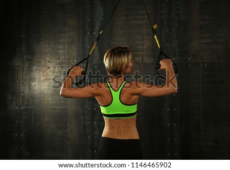 Similar – Image, Stock Photo Rear view portrait of one young middle age athletic woman at crossfit training, exercising with trx suspension fitness straps over dark background