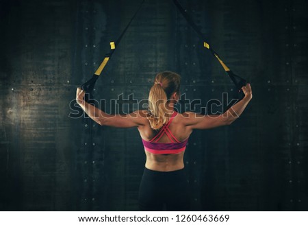 Similar – Image, Stock Photo Rear view portrait of one young middle age athletic woman at crossfit training, exercising with trx suspension fitness straps over dark background