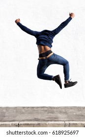 Rear view portrait of young black man jumping in air on sidewalk outdoors - Shutterstock ID 618925697