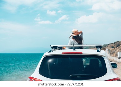 Rear View Of Pre Teen Child In Car Over Sea View On Summer Roadtrip To The Beach 