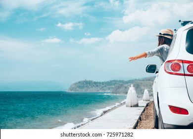 Rear View Of Pre Teen Child In Car Over Sea View On Summer Roadtrip To The Beach 