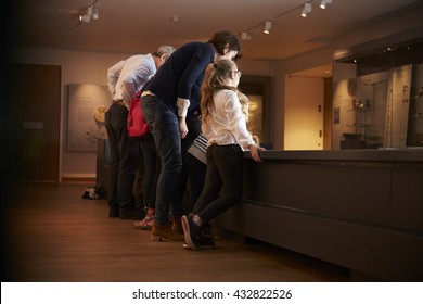 Rear View Of Pupils On School Trip To Museum Looking At Map