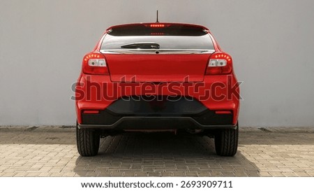 Rear view of a red compact hatchback car parked outdoors, highlighting sporty taillights, modern design, and urban driving practicality.