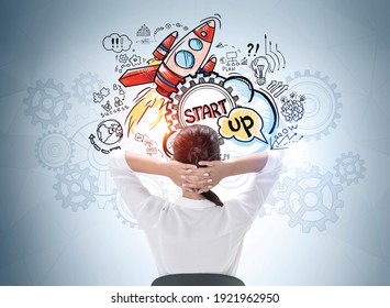 Rear view relaxed businesswoman and hands behind her head wondering about start up   how to succeed it  Concept success   new business project launch  Drawn colorful rocket sketch