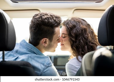 Rear view of a romantic young couple about to kiss each other in their car