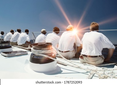 Rear View Of Sailing Crew With Lens Flare