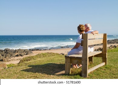 Rear View Of Senior Couple Cuddling On Beach