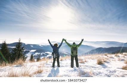 Rear view of senior couple hikers in snow-covered winter nature, stretching arms. - Powered by Shutterstock