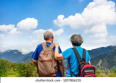 Rear View  Senior  Couple Hiking On The Mountain 