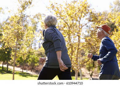 Rear View Of Senior Couple Power Walking Through Park