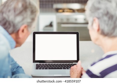 Rear View Of Senior Couple Using Laptop At Home