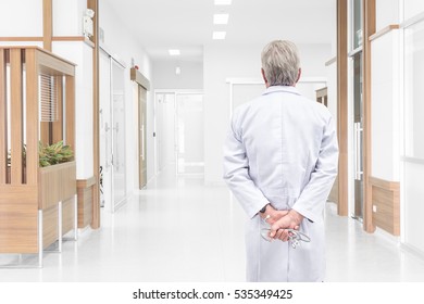 Rear View Senior Doctor Looking At The Hospital Hallway