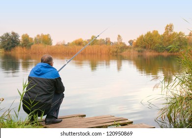 Rear View Of Senior Man Fishing On The Lake