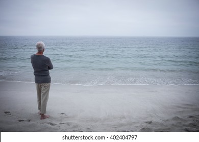 Rear View Of Senior Man Looking At Sea On The Beach