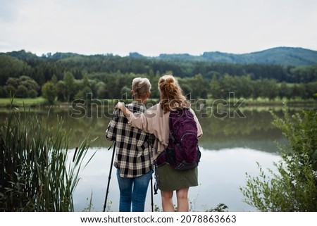 Similar – Foto Bild Rückansicht einer Frau mit rotem Hut, kurzer Jeans, Bluse und gemusterten Strümpfen steht auf einem großen Platz mit gemustertem Belag