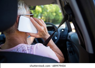 Rear view of senior woman talking on mobile phone in car - Powered by Shutterstock