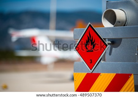 Rear view of service and refuelling truck on an airport with an aircraft in the blurry background. Chemical hazard, flammable liquids.