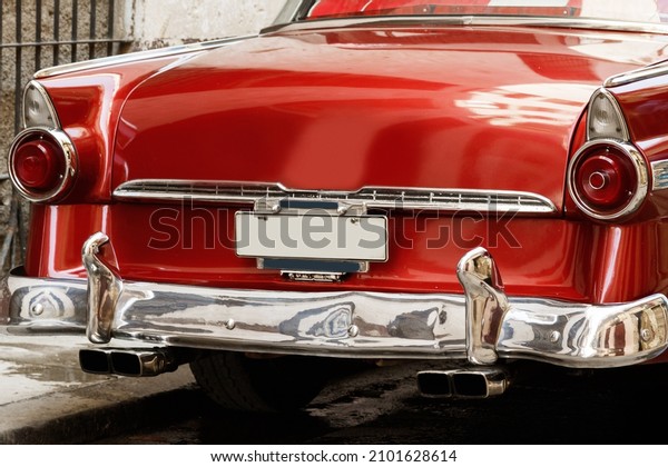 Rear\
view of a shiny vintage red car parked on\
street.