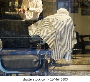 Rear view shot of handsome hairdresser cutting hair of male client. Hairstylist serving client at barber shop - Powered by Shutterstock