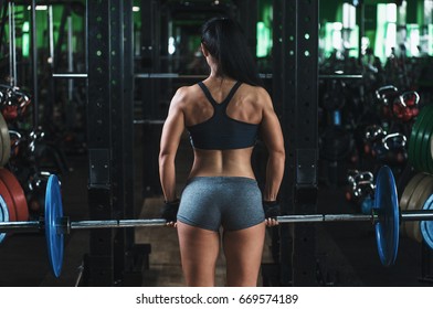 Rear View Shot Of A Strong Woman Doing Dead Lift With A Barbell In Gym
