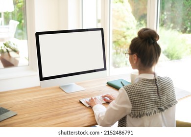 Rear View Shot Of Unrecognizable Woman Sitting In Front Of Blank Screen Computer While Typing On The Keyboard.