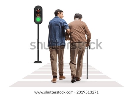 Rear view shot of a young man helping a senior across a street isolated on white background