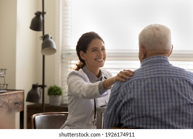 Rear view smiling female doctor wearing uniform comforting mature man, touching shoulder, good news, medical checkup results, physician therapist expressing empathy, psychological help concept