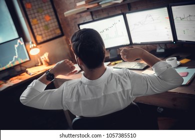 Rear view at stock trader broker stretching hands at workplace - Powered by Shutterstock