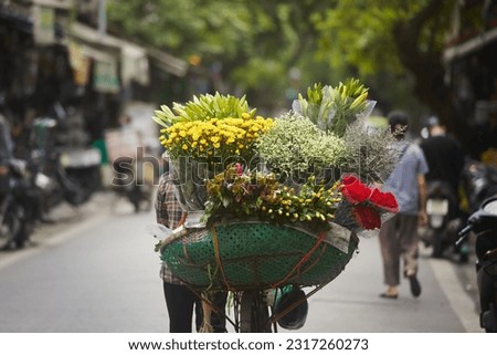Rear view of street flower seller on bicycle in Old Quarter in Hanoi, Vietnam.
