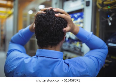 Rear view of stressed technician working on server maintenance - Powered by Shutterstock