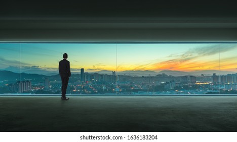 Rear view of successful businessman looking the city from his office , early morning scene  . - Powered by Shutterstock