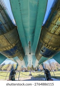 A rear view of the tail section of a Soviet Su-27 fighter jet, showing the two massive jet engine nozzles, the center boom, and the two vertical stabilizers.