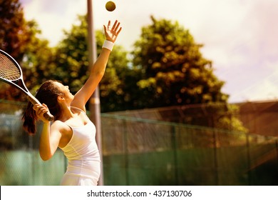 Rear view of tennis player serving during a match