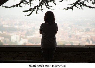 Rear view at thoughtful woman silhouette standing at view point looking at city watching urban cityscape vision pondering over question or problem, contemplating thinking of future loneliness concept - Powered by Shutterstock