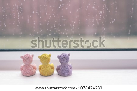 Rear view of three teddy bear sitting next to window  with rain drops in the rainy day, Group of sad teddy sitting together looking out of window watching rain outside,retro filte,love or Sad concept 