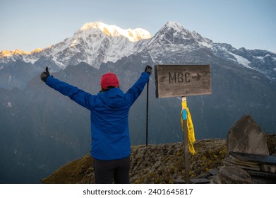 Rear view of tourist woman raised her hands after reached to Mardi Himal upper viewpoint in Nepal. Mardi Himal Trek is one of the newly popular trekking route in the Nepal.