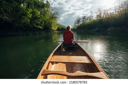 Rear view of travel woman rowing the boat on lake