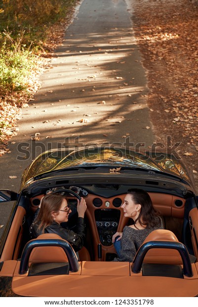 Rear view of two\
women friends in cabliolet