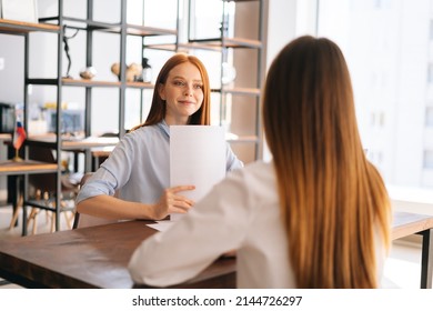 Rear view of unrecognizable young woman employers being interviewed for job in design company, having conversations about successful startup, sitting at desk opposite each other. - Powered by Shutterstock